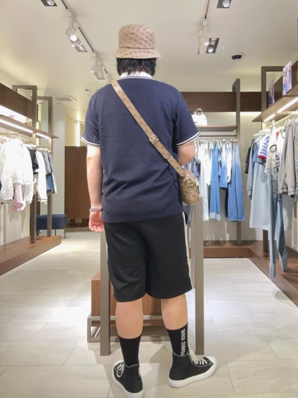 ベージュ系のショルダーバッグ、ブラック系のその他パンツ、ブルー系のポロシャツを着用したメンズの夏コーディネートの2枚目の写真