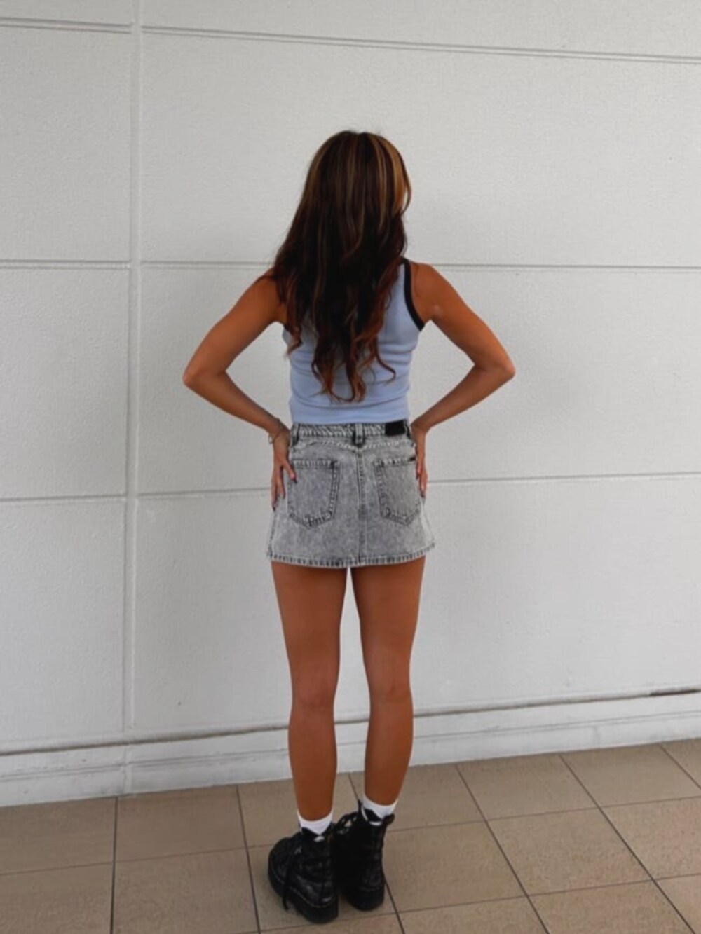 ブルー系のタンクトップ、グレー系のデニムパンツを着用したレディースの秋コーディネートの2枚目の写真