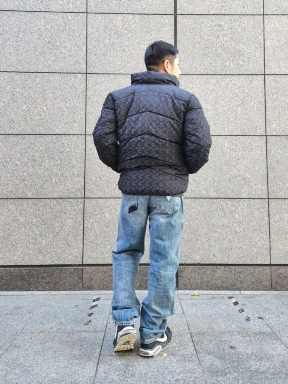 ブルー系のデニムパンツ、ブラック系のニット/セーター、ブラック系のその他アウターを着用したメンズの冬コーディネートの2枚目の写真