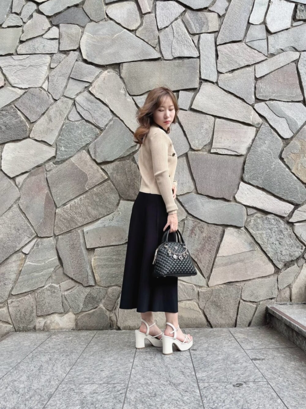 ベージュ系のカーディガン/ボレロ、ブラック系のワンピース、ブラック系のショルダーバッグを着用したレディースの秋コーディネートの3枚目の写真