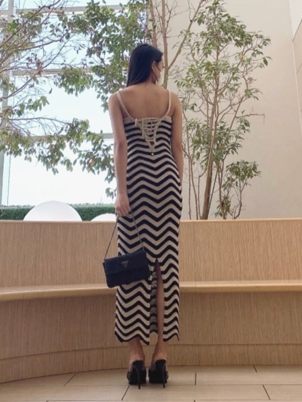 ブラック系のワンピースを着用したレディースの夏コーディネートの2枚目の写真