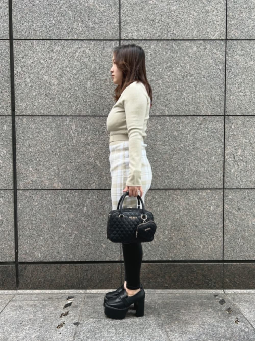 ホワイト系のワンピース、ブラック系のハンドバッグを着用したレディースの冬コーディネートの3枚目の写真