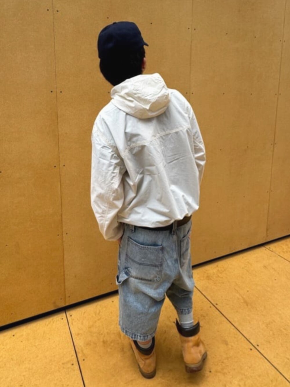 ホワイト系のナイロンジャケット、ブラック系のTシャツ/カットソー、ブルー系のデニムパンツを着用したメンズの夏コーディネートの2枚目の写真