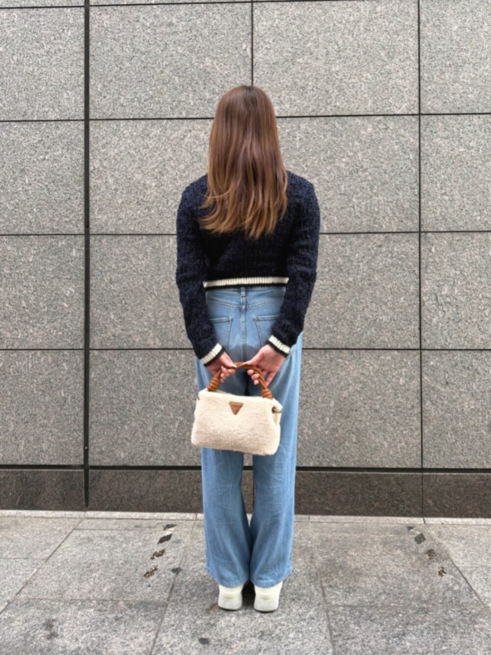 ブルー系のデニムパンツ、イエロー系のショルダーバッグ、ブルー系のカーディガン/ボレロを着用したレディースの冬コーディネートの2枚目の写真