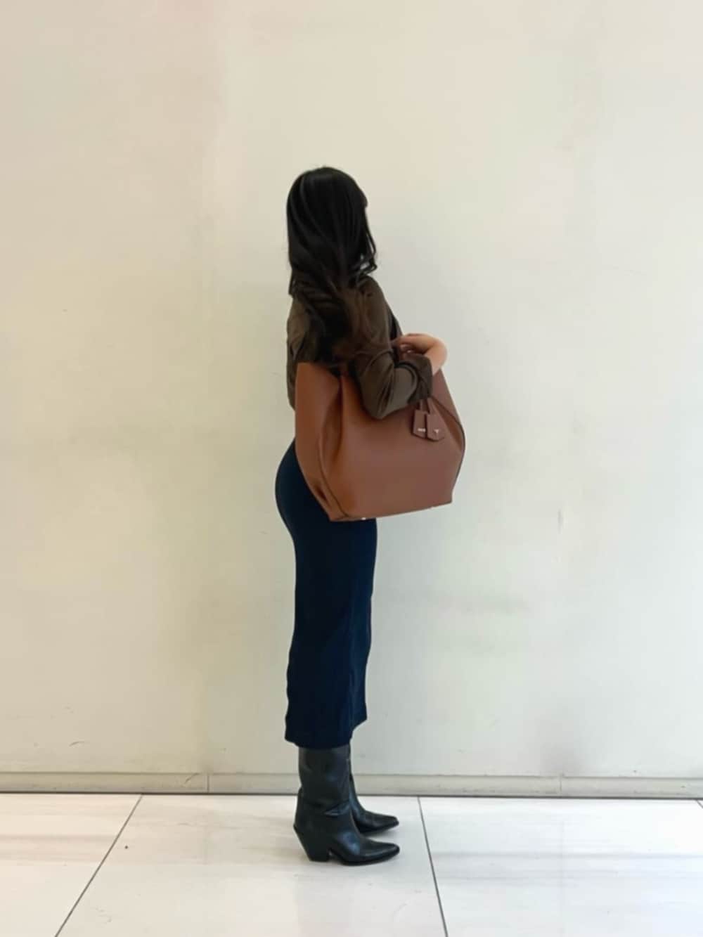 ブラウン系のトートバッグ、ブラウン系のシャツ/ブラウス、ブルー系のワンピースを着用したレディースの冬コーディネートの3枚目の写真