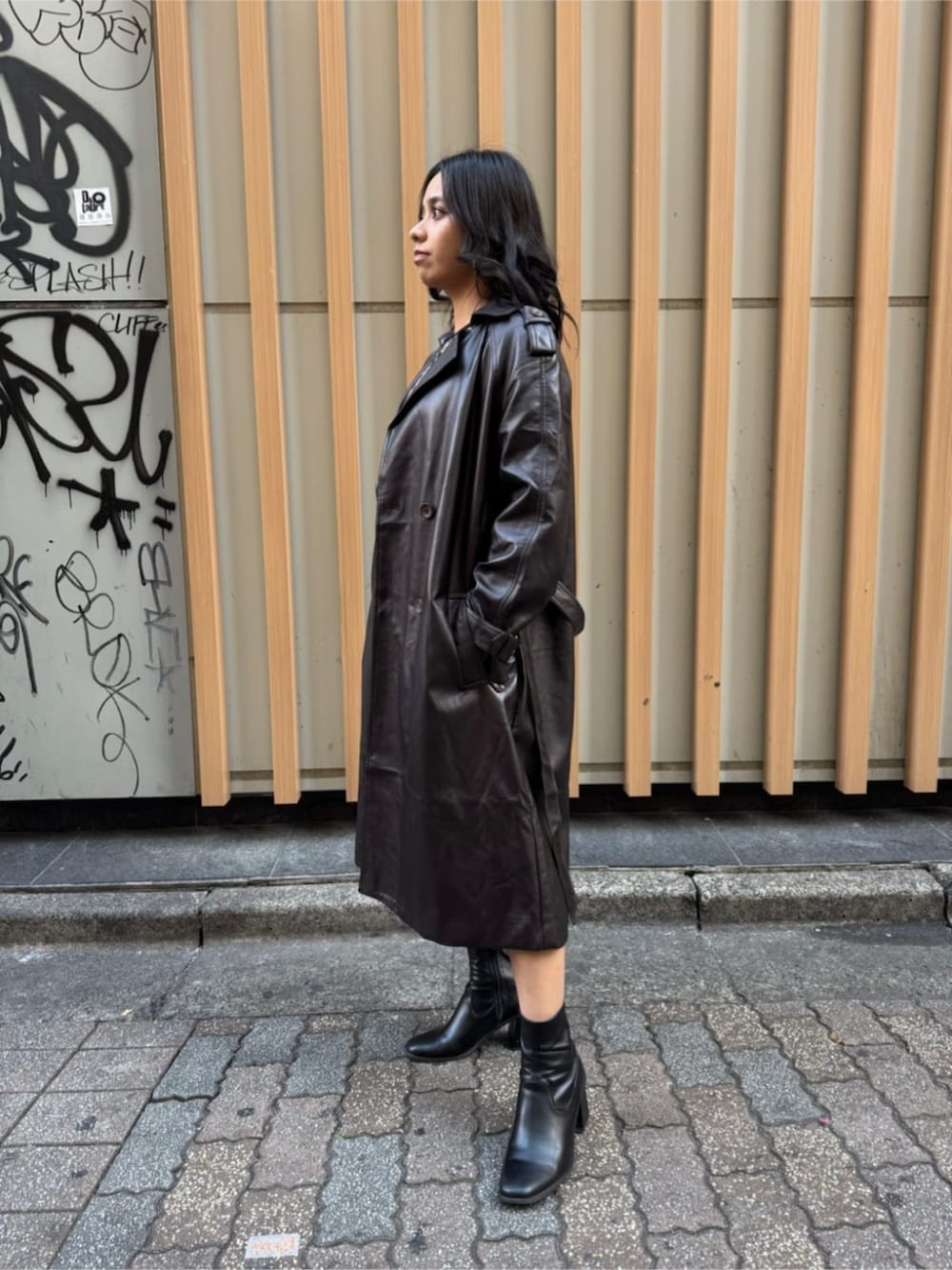 ブラウン系のワンピース、ブラウン系のトレンチコートを着用したレディースの春コーディネートの2枚目の写真