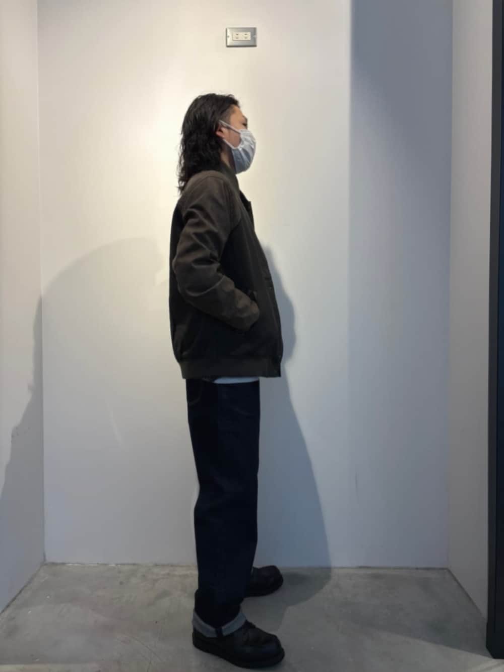 ブルー系のデニムパンツ、グレー系のニット/セーター、グリーン系のブルゾンを着用したメンズの冬コーディネートの3枚目の写真