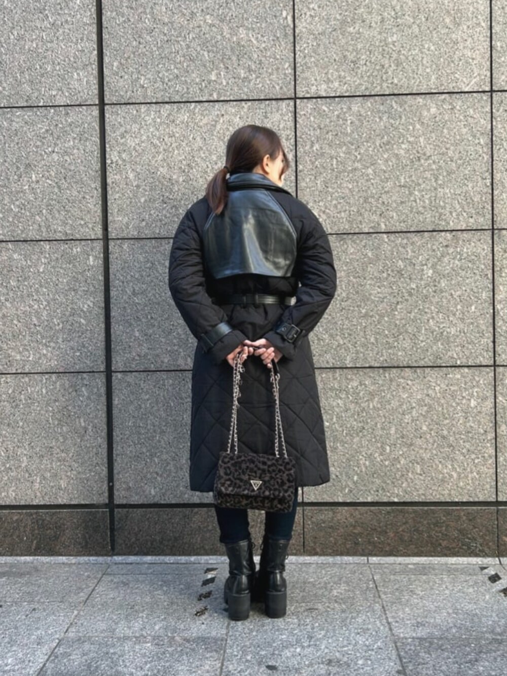 ブルー系のデニムパンツ、ブラック系のカーディガン/ボレロ、ブラック系のトレンチコートを着用したレディースの秋コーディネートの2枚目の写真