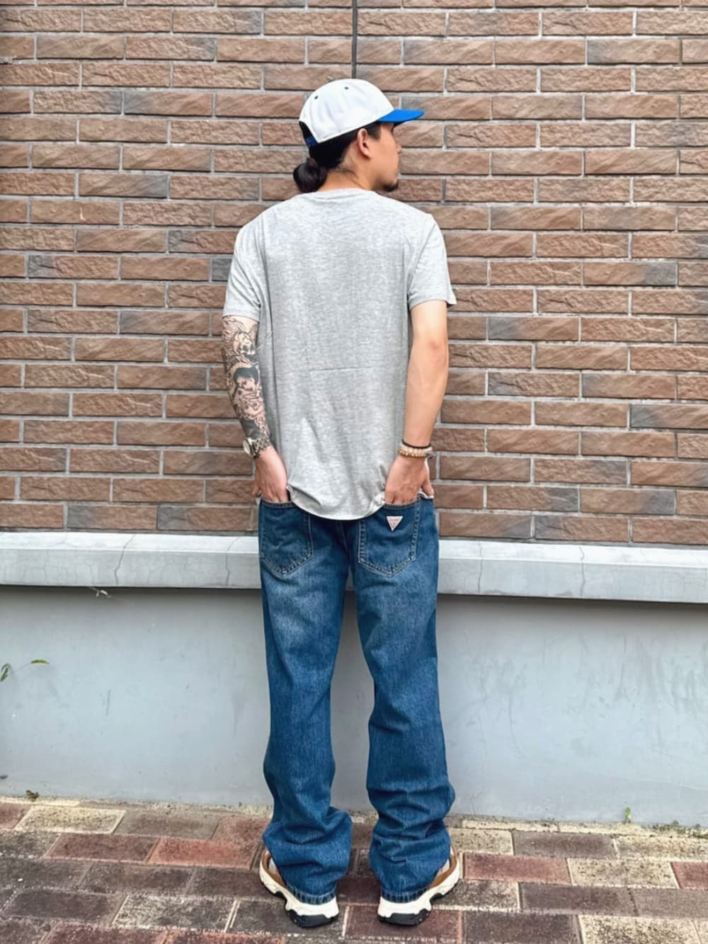 ブルー系のデニムパンツ、グレー系のTシャツ/カットソーを着用したメンズの夏コーディネートの2枚目の写真