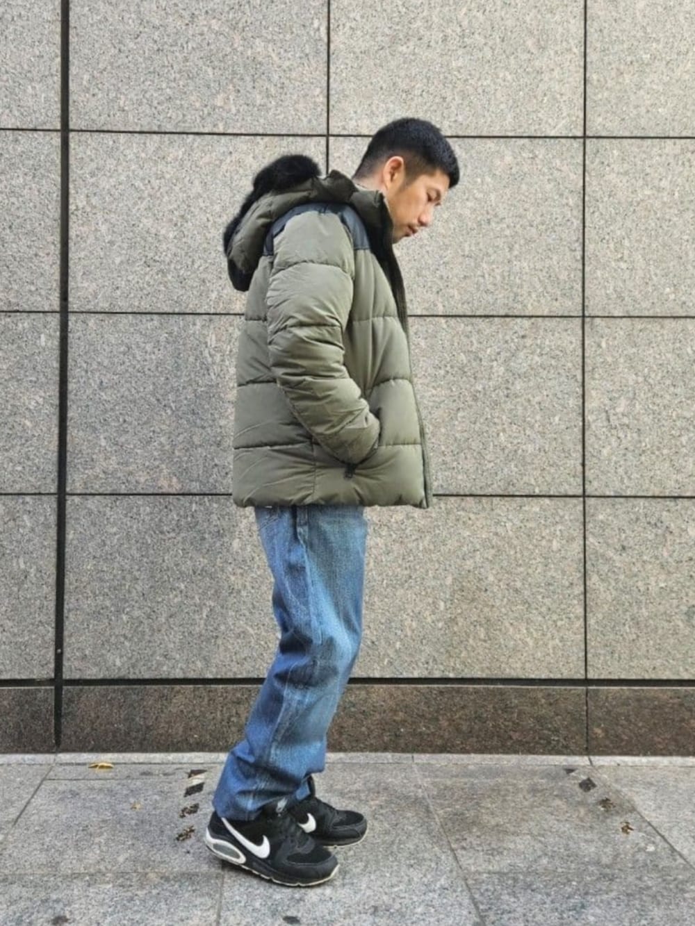 ブルー系のデニムパンツ、グレー系のスウェット、グリーン系のその他アウターを着用したメンズの冬コーディネートの3枚目の写真