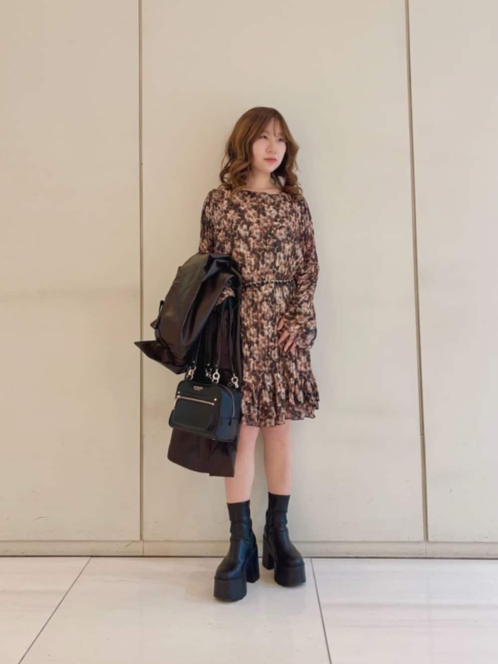 ブラウン系のワンピース、ブラウン系のトレンチコート、ブラック系のショルダーバッグを着用したレディースの冬コーディネートの4枚目の写真