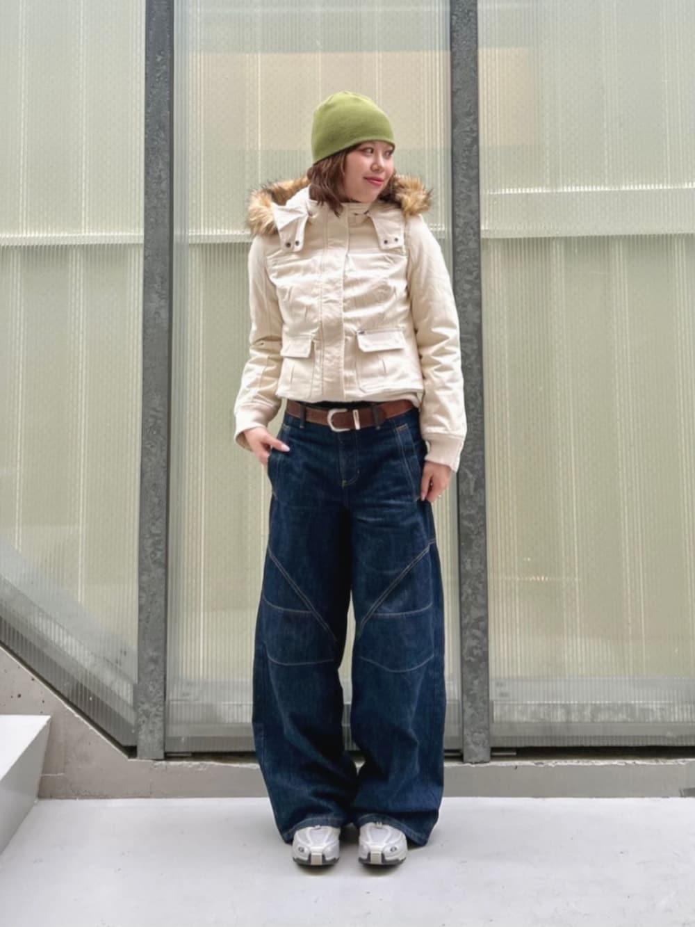 ブルー系のデニムパンツ、ブラック系のブルゾン、ブラック系のボクサーパンツを着用したレディースの冬コーディネートの4枚目の写真