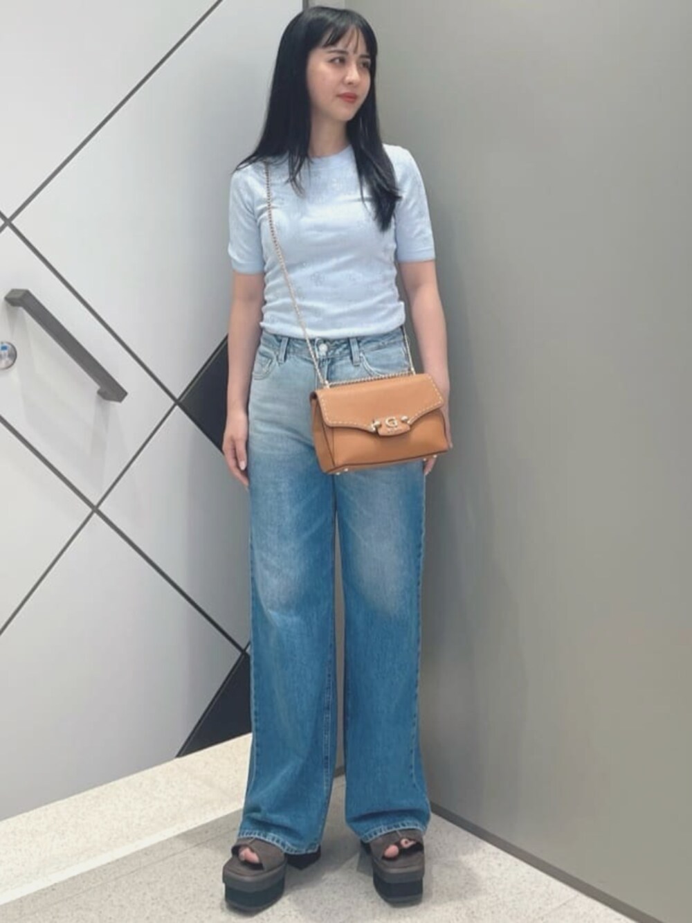 ブルー系のデニムパンツ、イエロー系のショルダーバッグ、ブルー系のニット/セーターを着用したレディースの夏コーディネートの4枚目の写真