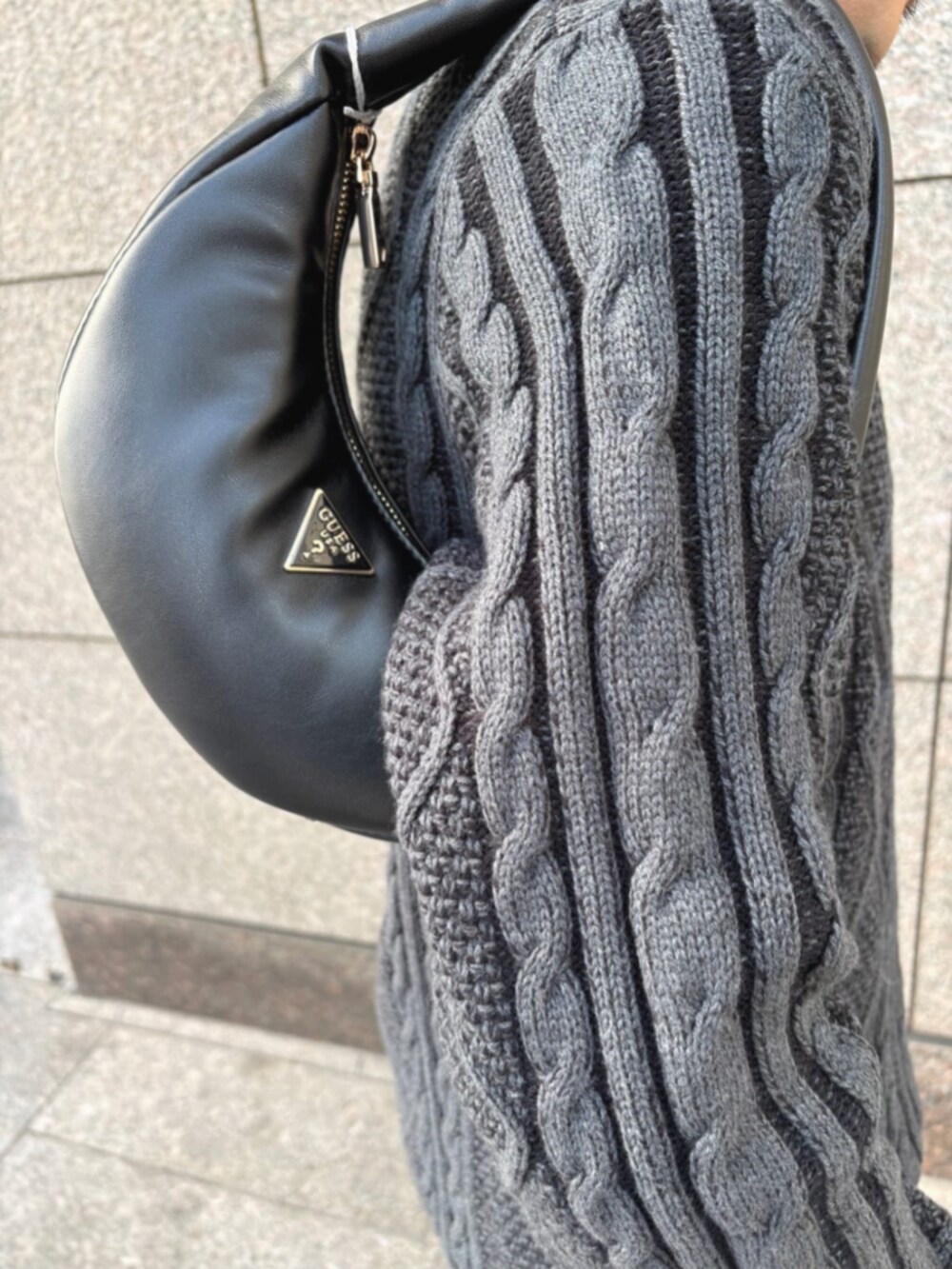 グレー系のデニムパンツ、ブラック系のショルダーバッグ、ブラック系のニット/セーターを着用したメンズの冬コーディネートの4枚目の写真