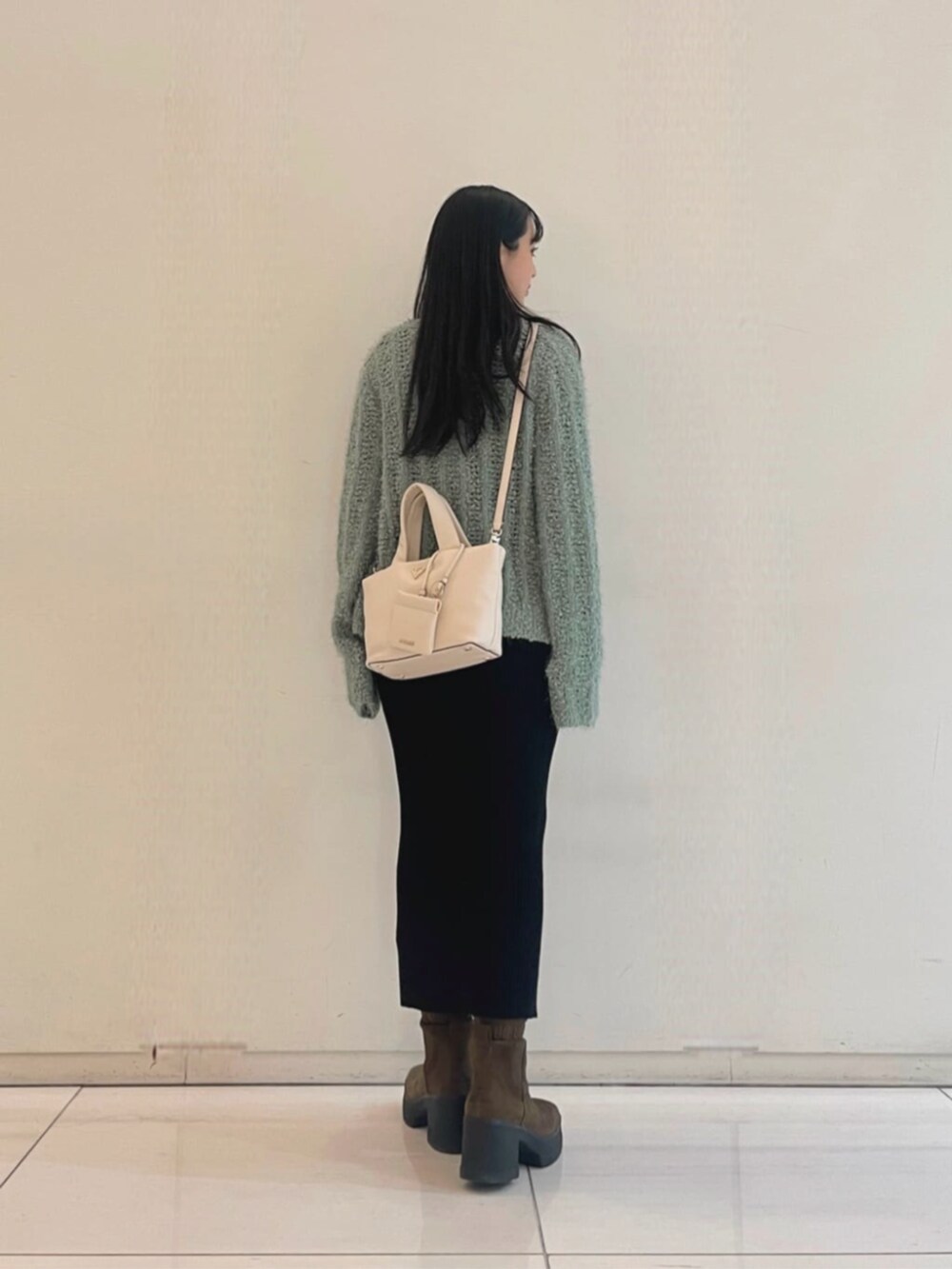 ブラック系のワンピース、グリーン系のカーディガン/ボレロ、ホワイト系のトートバッグを着用したレディースの秋コーディネートの2枚目の写真