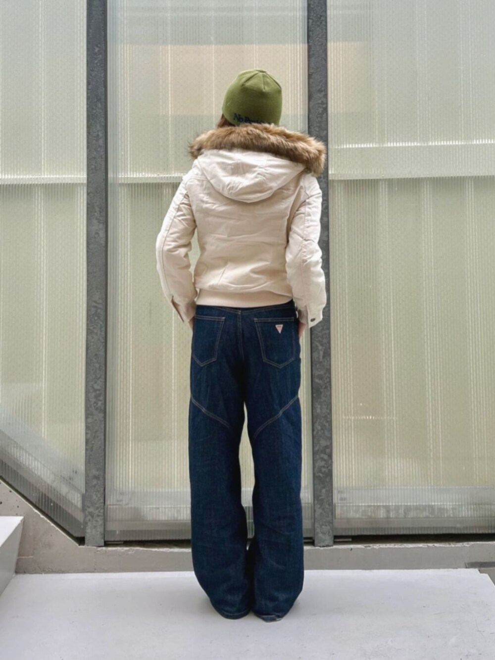 ブルー系のデニムパンツ、ブラック系のブルゾン、ブラック系のボクサーパンツを着用したレディースの冬コーディネートの2枚目の写真