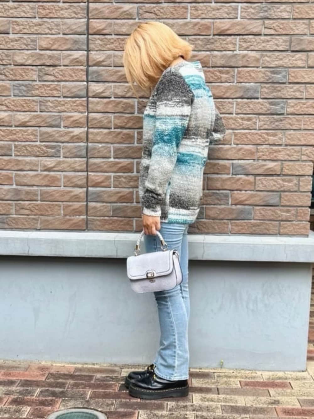 ホワイト系のタンクトップ、その他のカーディガン/ボレロ、パープル系のショルダーバッグを着用したレディースの秋コーディネートの3枚目の写真