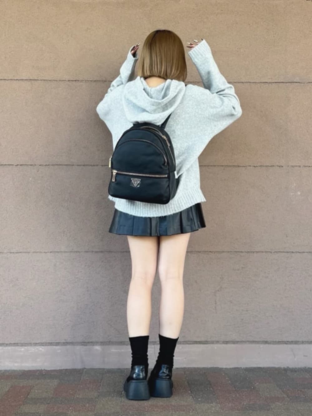 ブラック系のスカート、グレー系のパーカー、ブラック系のバックパック/リュックを着用したレディースの冬コーディネートの2枚目の写真