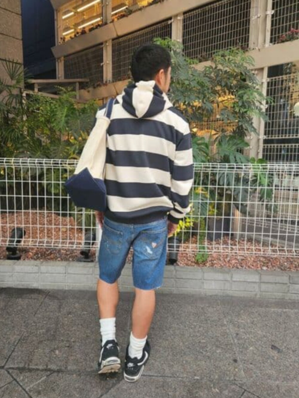 ブルー系のパーカー、ブルー系のトートバッグを着用したメンズの秋コーディネートの3枚目の写真