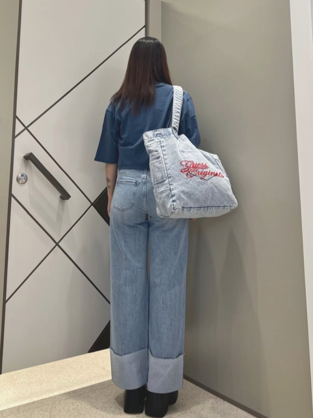 ブルー系のトートバッグ、ブルー系のTシャツ/カットソー、ブルー系のデニムパンツを着用したレディースの夏コーディネートの2枚目の写真