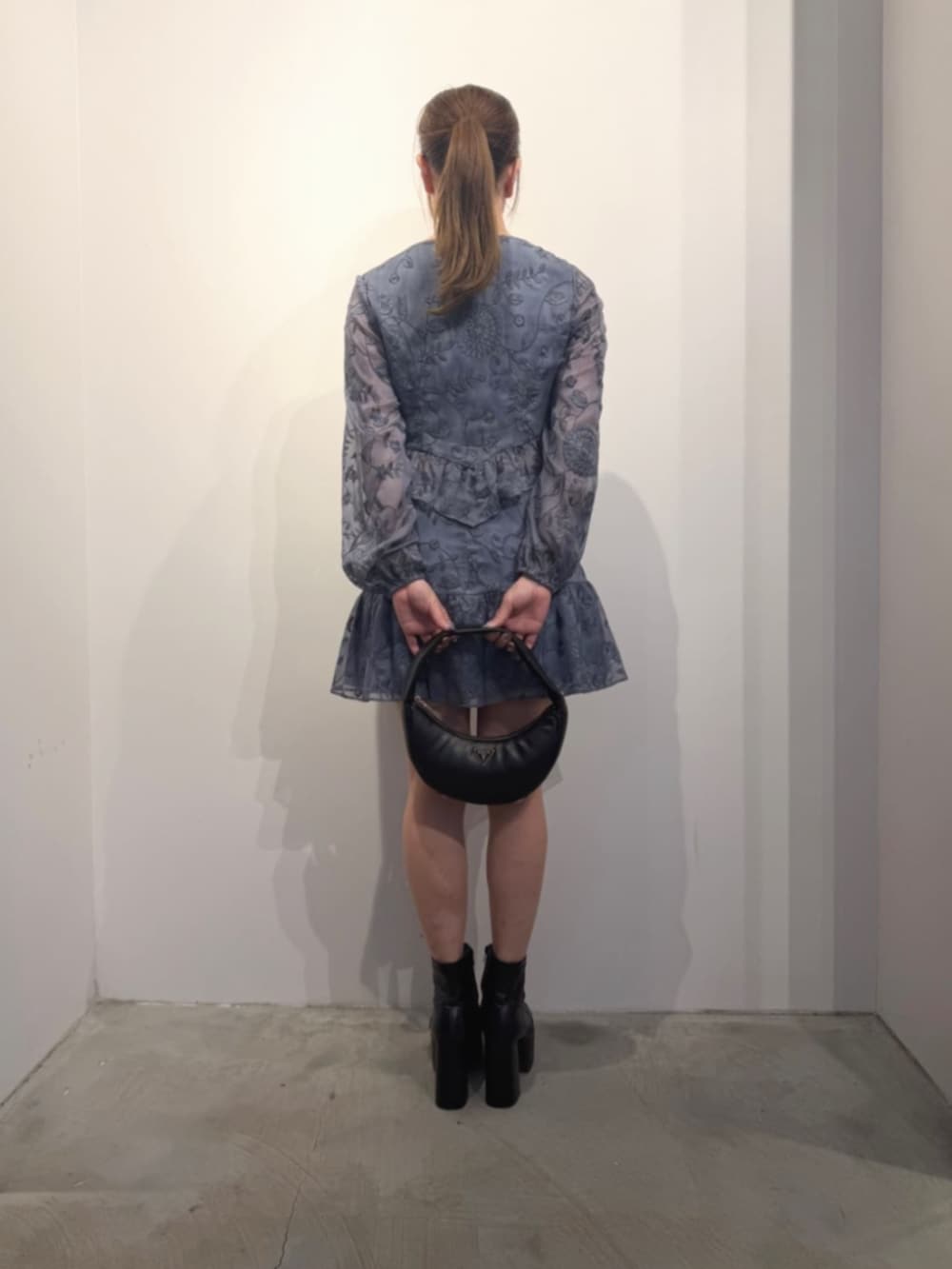 ブラック系のショルダーバッグ、ブルー系のシャツ/ブラウス、ブルー系のスカートを着用したレディースの冬コーディネートの2枚目の写真