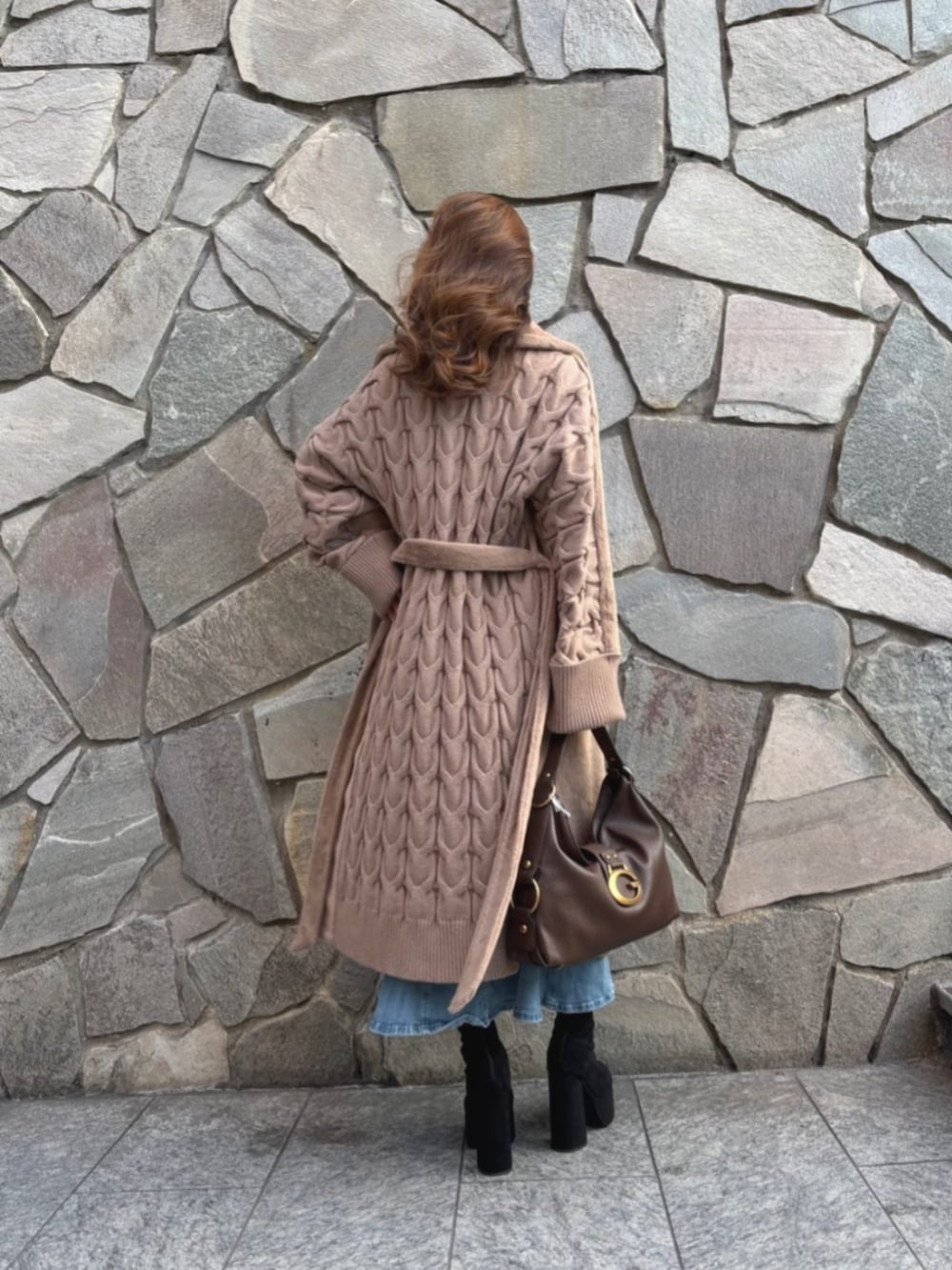 ブラック系のニット/セーター、ブラウン系のショルダーバッグ、ブルー系のデニムスカートを着用したレディースの秋コーディネートの2枚目の写真