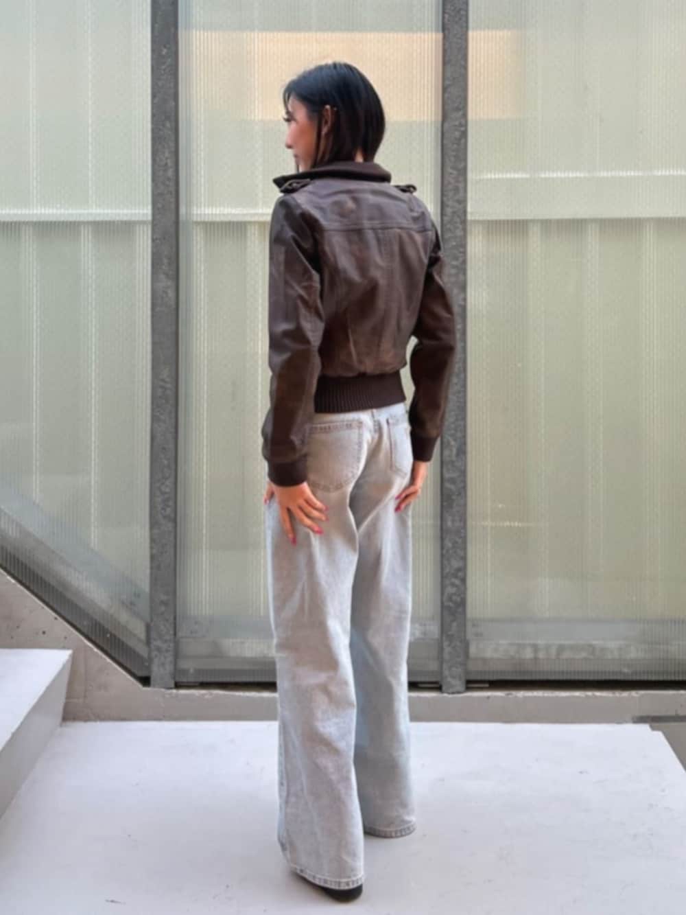 ブルー系のデニムパンツ、ブラウン系のミリタリージャケットを着用したレディースの冬コーディネートの2枚目の写真