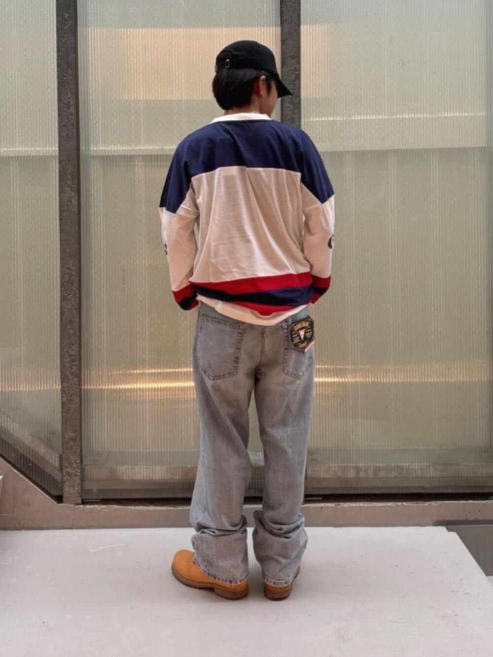 ホワイト系のスウェット、ブルー系のデニムパンツを着用したメンズの秋コーディネートの2枚目の写真