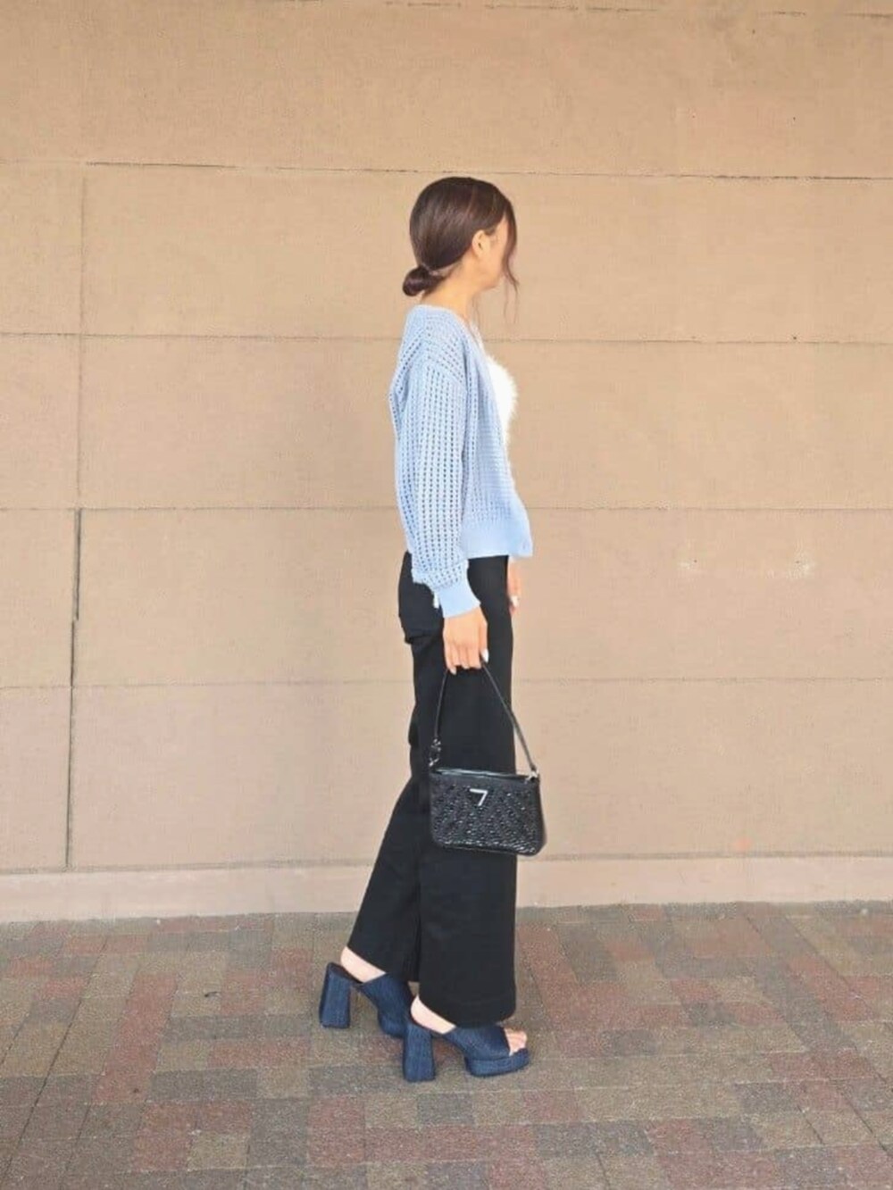 ブラック系のデニムパンツ、ブルー系のカーディガン/ボレロ、その他のキャミソールを着用したレディースの秋コーディネートの3枚目の写真