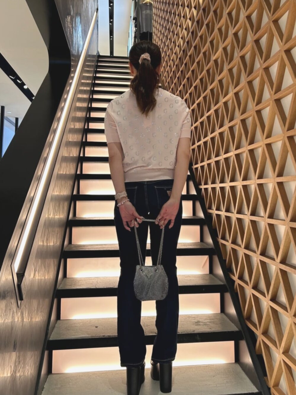 ブルー系のデニムパンツ、ピンク系のTシャツ/カットソー、シルバー系のショルダーバッグを着用したレディースの夏コーディネートの2枚目の写真