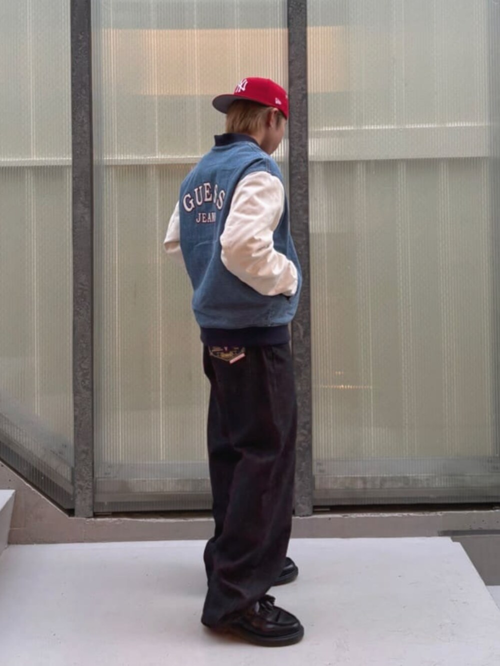 ブラック系のスウェット、ブルー系のスタジャン、ブラック系のデニムパンツを着用したメンズの秋コーディネートの3枚目の写真