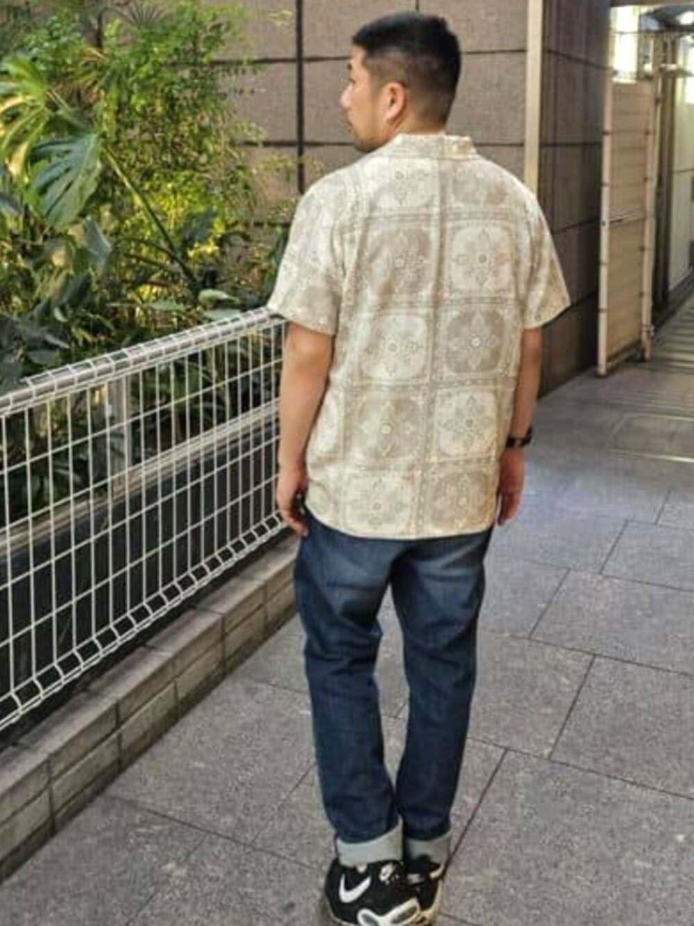 ブルー系のデニムパンツ、ベージュ系のシャツ/ブラウス、グリーン系のTシャツ/カットソーを着用したメンズの夏コーディネートの2枚目の写真