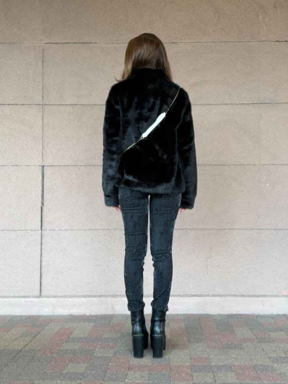 ブラック系のデニムパンツ、ホワイト系のショルダーバッグ、ベージュ系のTシャツ/カットソーを着用したレディースの春コーディネートの2枚目の写真