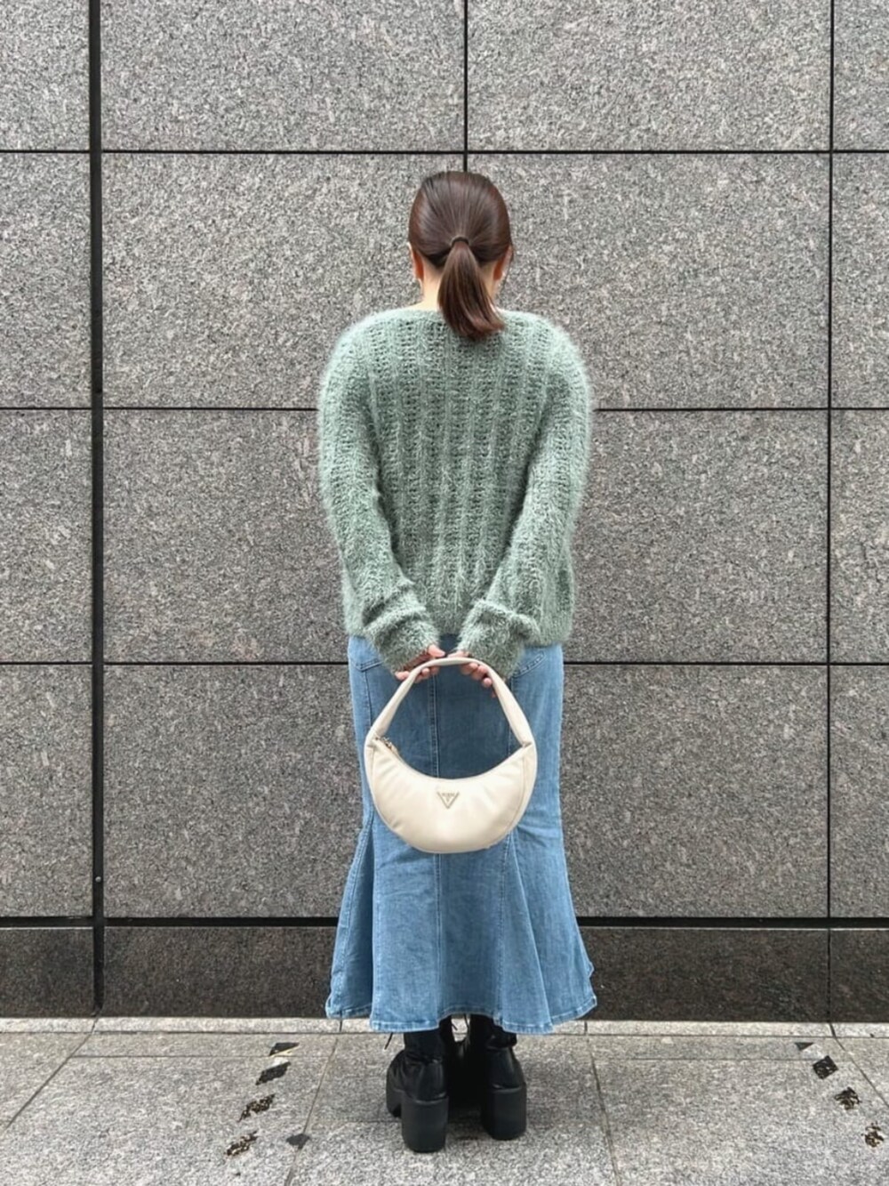 ブルー系のデニムスカート、グリーン系のカーディガン/ボレロ、グリーン系のキャミソールを着用したレディースの秋コーディネートの2枚目の写真