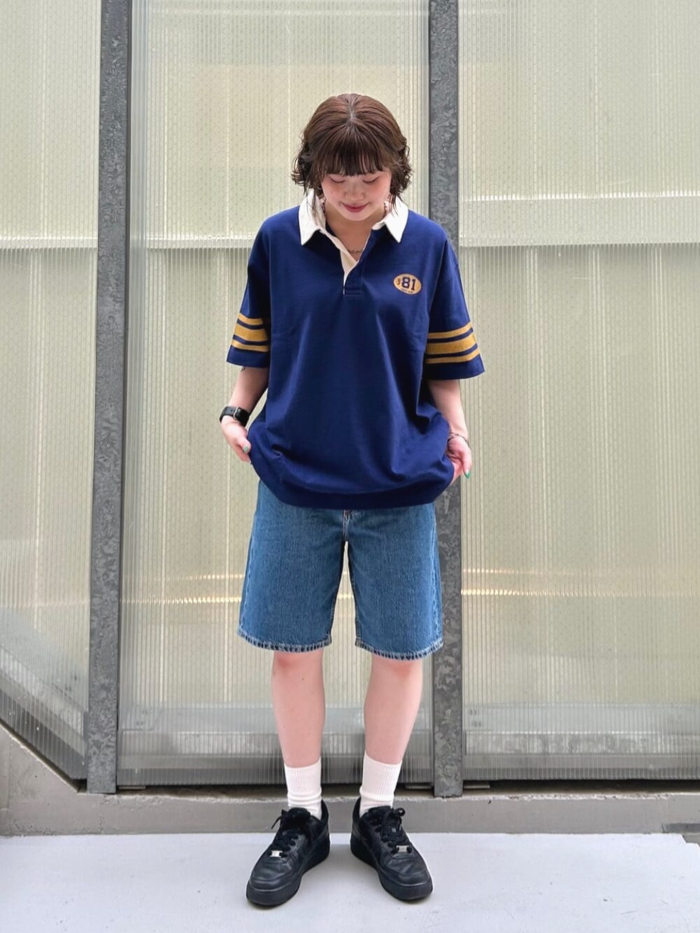 ブルー系のポロシャツ、ブルー系のデニムパンツを着用したレディースの夏コーディネートの4枚目の写真
