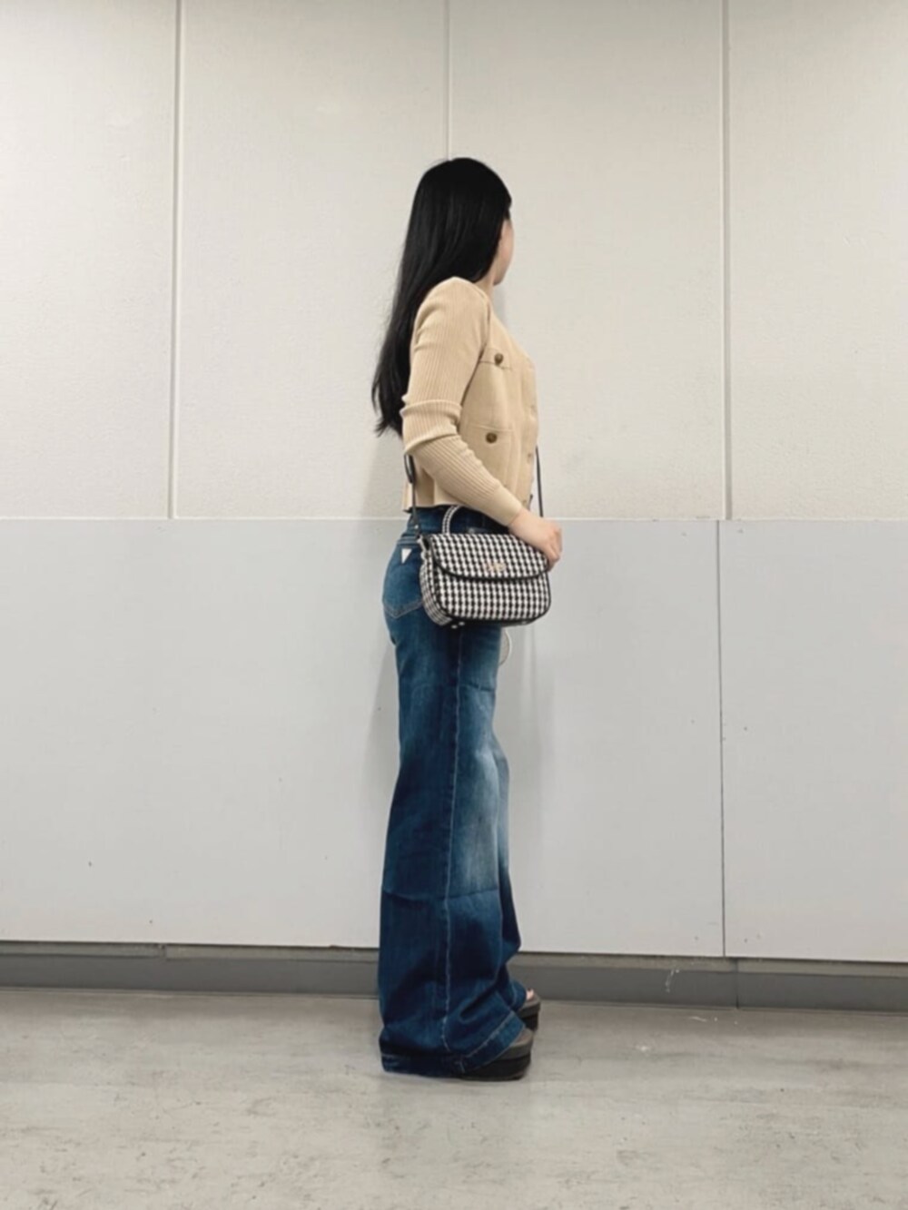 ベージュ系のカーディガン/ボレロ、ブルー系のデニムパンツ、ブラック系のショルダーバッグを着用したレディースの秋コーディネートの3枚目の写真