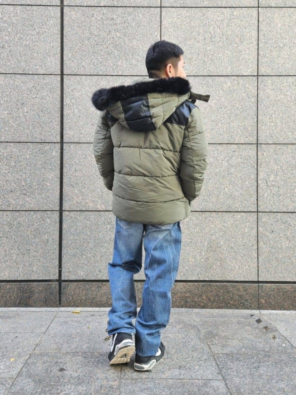 ブルー系のデニムパンツ、グレー系のスウェット、グリーン系のその他アウターを着用したメンズの冬コーディネートの2枚目の写真