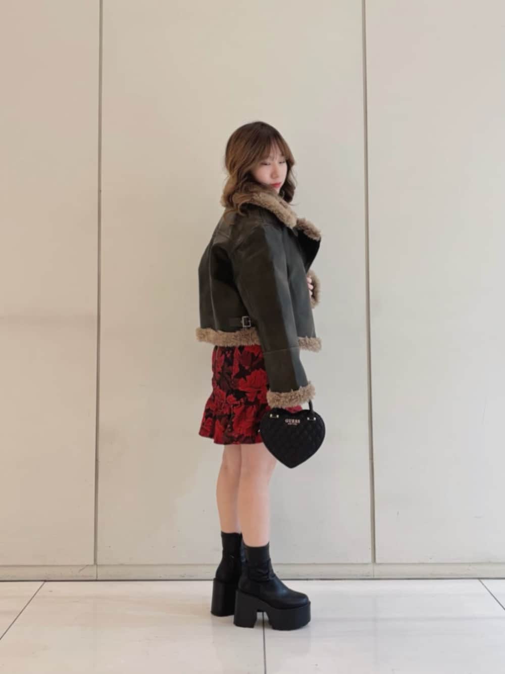 ブラック系のショルダーバッグ、ブラウン系のライダースジャケット、その他のワンピースを着用したレディースの冬コーディネートの3枚目の写真