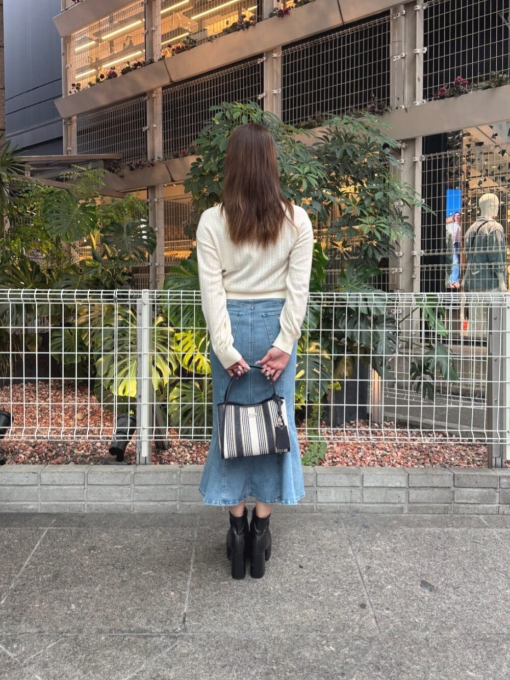 ベージュ系のカーディガン/ボレロ、ブルー系のデニムスカート、ブルー系のショルダーバッグを着用したレディースの秋コーディネートの2枚目の写真