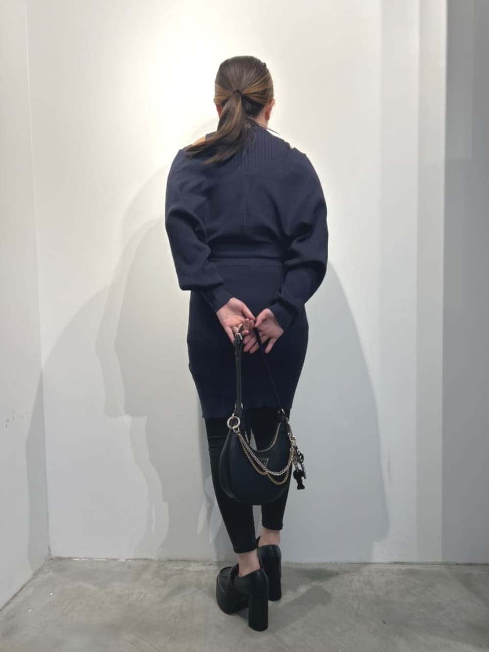 ブルー系のワンピース、ブラック系のショルダーバッグを着用したレディースの冬コーディネートの2枚目の写真