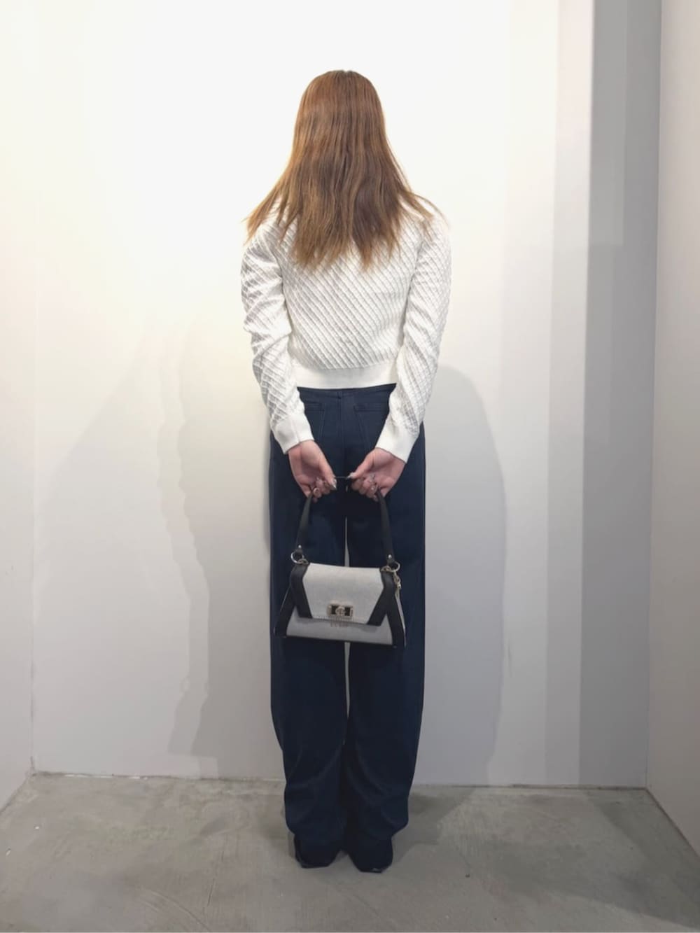 ブラック系のショルダーバッグ、ブルー系のデニムパンツ、ベージュ系のタンクトップを着用したレディースの春コーディネートの3枚目の写真