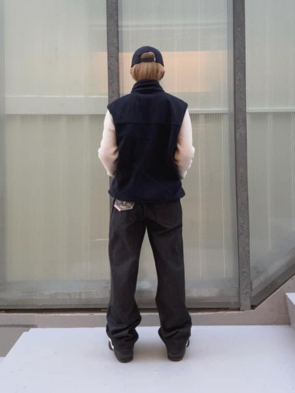 ブラック系のデニムパンツ、イエロー系のベスト、その他のボクサーパンツを着用したメンズの秋コーディネートの2枚目の写真