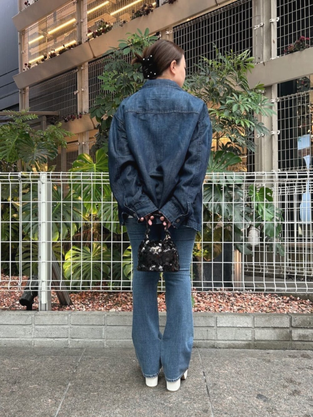 ブルー系のデニムパンツ、ブラック系のショルダーバッグ、ブルー系のシャツ/ブラウスを着用したレディースの秋コーディネートの2枚目の写真