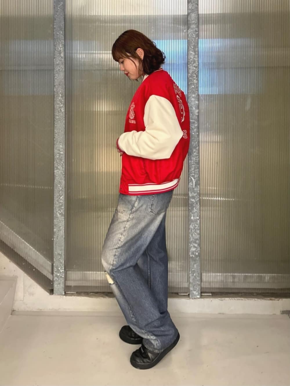 ホワイト系のTシャツ/カットソー、ブルー系のデニムパンツ、レッド系のスタジャンを着用したレディースの秋コーディネートの3枚目の写真