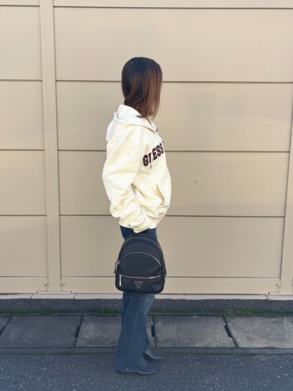 ブラック系のバックパック/リュック、ホワイト系のパーカーを着用したレディースの秋コーディネートの3枚目の写真