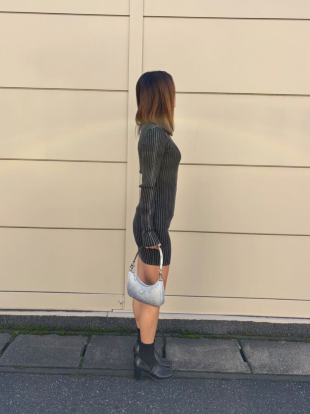 ブラック系のワンピース、シルバー系のハンドバッグを着用したレディースの秋コーディネートの3枚目の写真