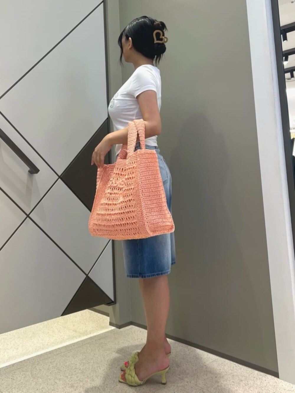 ブルー系のデニムパンツ、ホワイト系のTシャツ/カットソー、ピンク系のトートバッグを着用したレディースの夏コーディネートの3枚目の写真