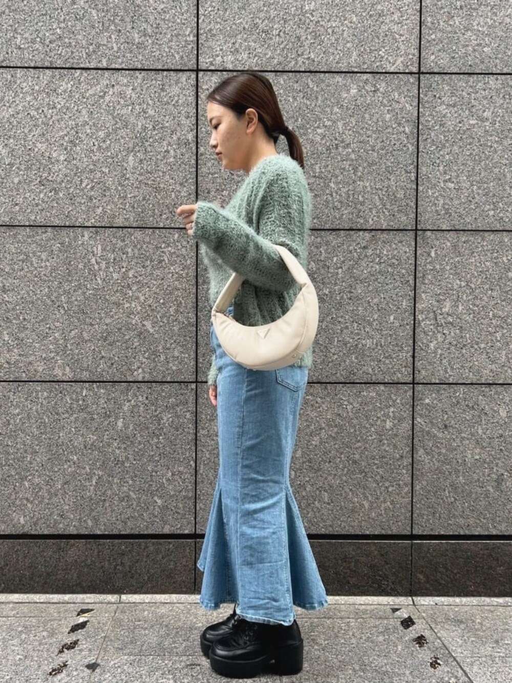 ブルー系のデニムスカート、グリーン系のカーディガン/ボレロ、グリーン系のキャミソールを着用したレディースの秋コーディネートの3枚目の写真