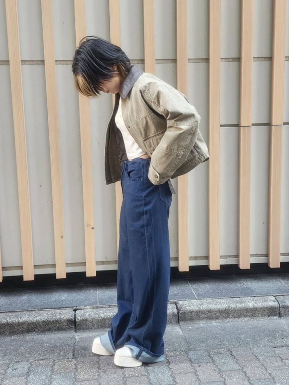 ホワイト系のTシャツ/カットソー、ブルー系のデニムパンツ、グリーン系のミリタリージャケットを着用したレディースの冬コーディネートの4枚目の写真