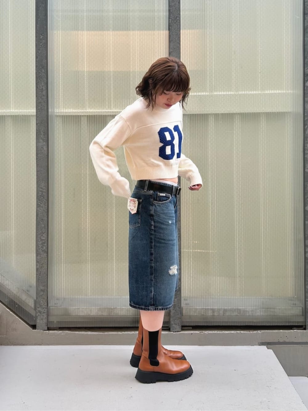 ブルー系のデニムパンツ、ホワイト系のニット/セーターを着用したレディースの秋コーディネートの3枚目の写真